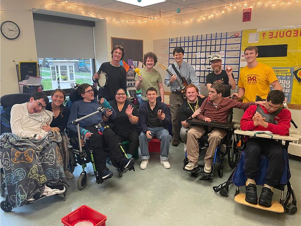 A classroom of teachers and students, some holding musical instruments